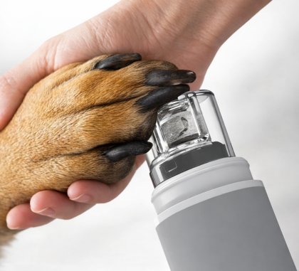 Close-up of a dog’s paw being trimmed with an electric nail grinder featuring a clear adjustable dust collecting cap
